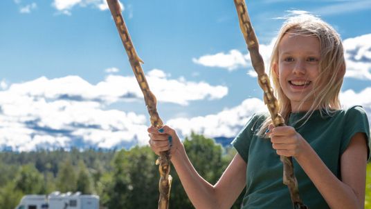 Kid laughing on a swing